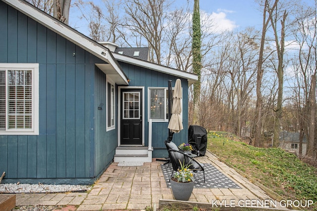 view of exterior entry with a patio