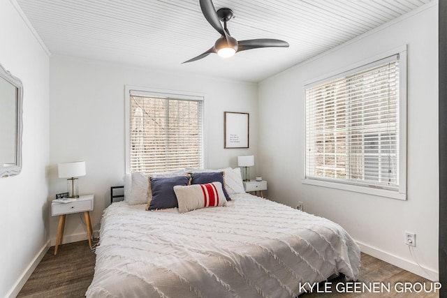 bedroom with baseboards, crown molding, dark wood-type flooring, and a ceiling fan