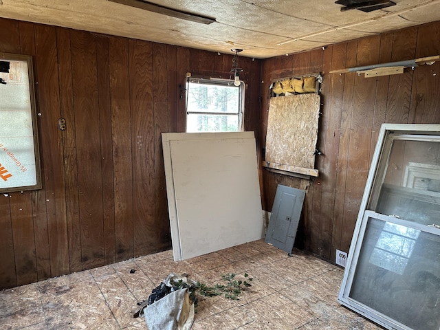 unfurnished room with wood walls