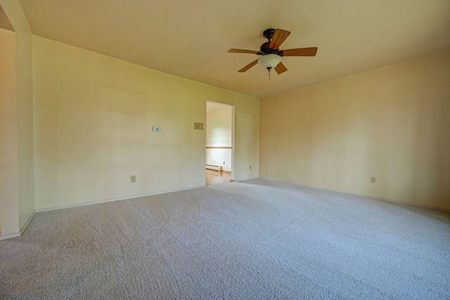 carpeted spare room with a ceiling fan, baseboards, and a baseboard heating unit
