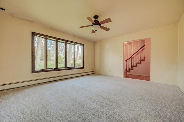 carpeted spare room with stairway, baseboards, ceiling fan, and a baseboard radiator