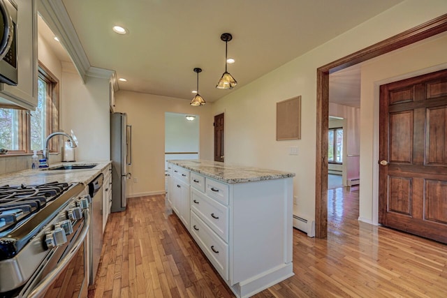 kitchen with a sink, a baseboard radiator, light wood finished floors, stainless steel appliances, and white cabinetry