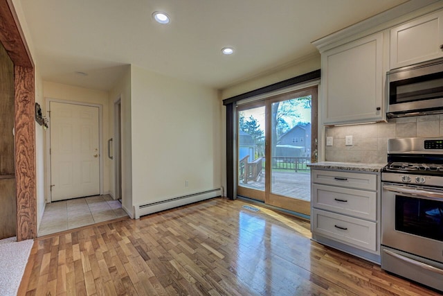 kitchen featuring tasteful backsplash, light wood-type flooring, a baseboard heating unit, stainless steel appliances, and recessed lighting