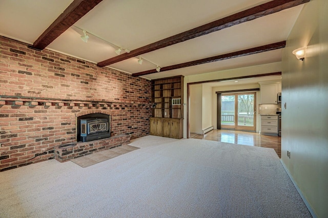 unfurnished living room with brick wall, baseboards, beam ceiling, and track lighting