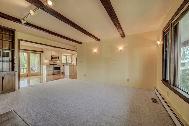 unfurnished living room with a baseboard radiator, beamed ceiling, light carpet, and visible vents