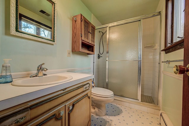 full bath featuring vanity, visible vents, toilet, a shower stall, and a baseboard radiator