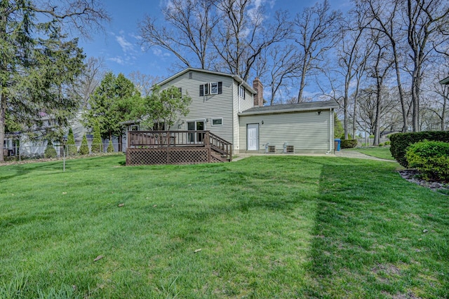 back of property with a lawn, fence, a wooden deck, and a chimney