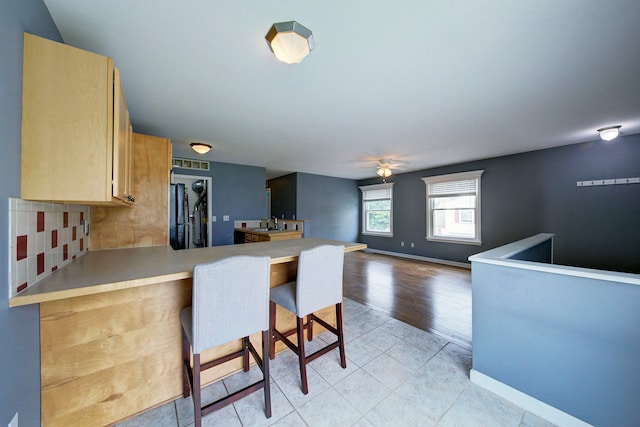 3067 Oakridge, Lake Orion, MI 48360 - kitchen with a peninsula, a breakfast bar, light countertops, and tasteful backsplash