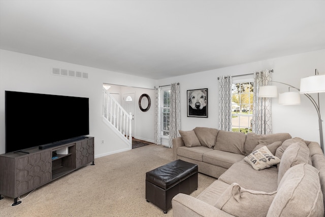 living area featuring visible vents, carpet, stairs, and baseboards