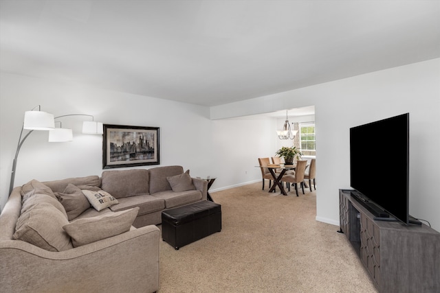living room with baseboards, an inviting chandelier, and light carpet