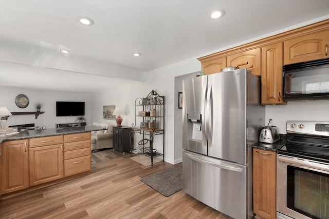 kitchen featuring recessed lighting, open floor plan, light wood finished floors, and appliances with stainless steel finishes