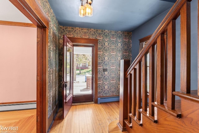 entrance foyer with wood-type flooring, wallpapered walls, and a baseboard heating unit