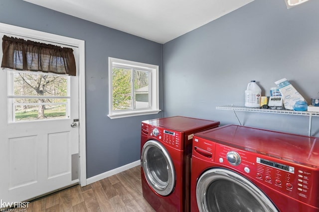 washroom featuring laundry area, baseboards, wood finished floors, and washer and dryer