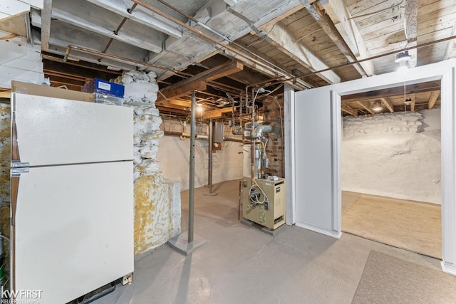 unfinished basement featuring freestanding refrigerator