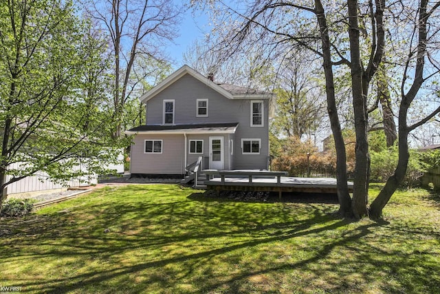 rear view of property featuring a wooden deck and a yard
