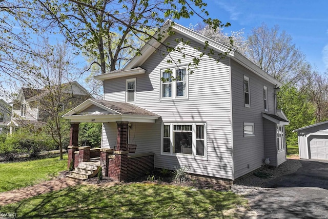 view of front of house with covered porch, an outdoor structure, and a front yard