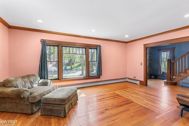 living area featuring crown molding, baseboard heating, and light wood-style floors