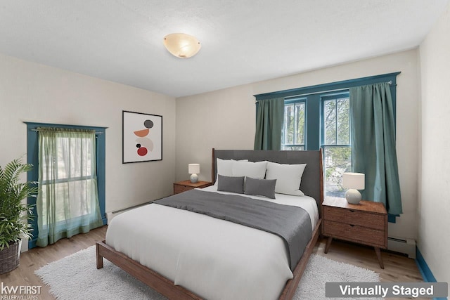 bedroom featuring a baseboard radiator and wood finished floors