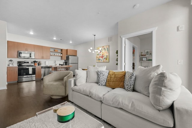 living area with dark wood-style flooring, visible vents, an inviting chandelier, and recessed lighting