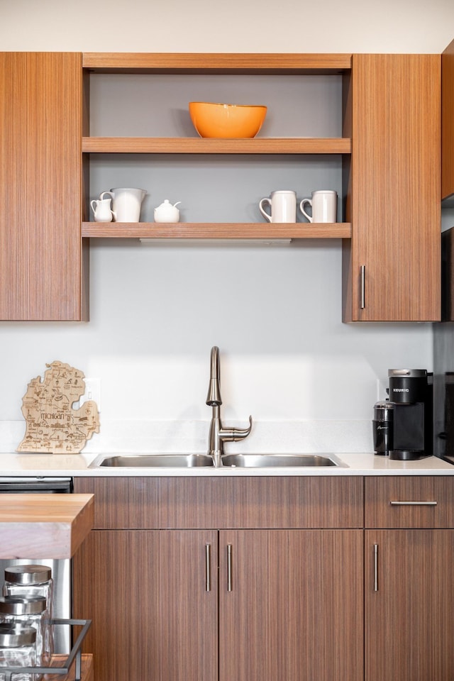 kitchen with open shelves, a sink, and light countertops