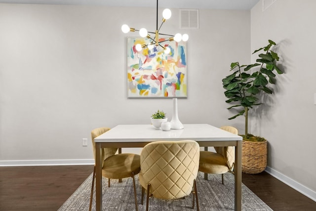 dining room with visible vents, baseboards, wood finished floors, and a chandelier