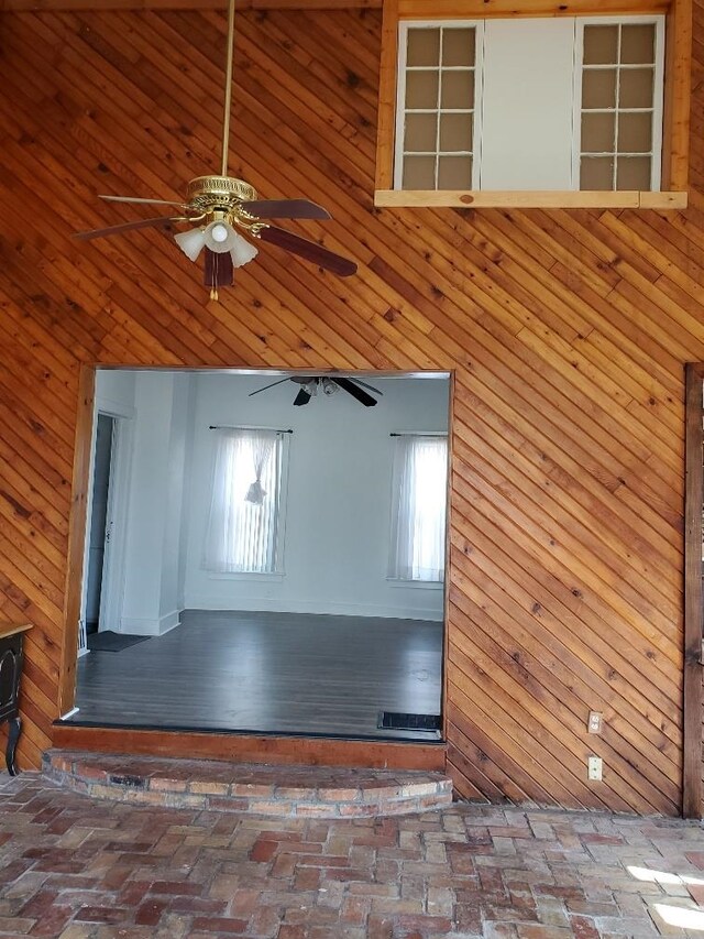 429 S Arnold, Mount Pleasant, MI 48858 - interior space featuring a ceiling fan, wood walls, a healthy amount of sunlight, and brick floor