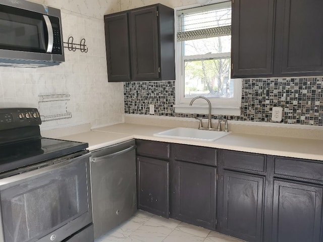 429 S Arnold, Mount Pleasant, MI 48858 - kitchen featuring decorative backsplash, a sink, light countertops, marble finish floor, and stainless steel appliances