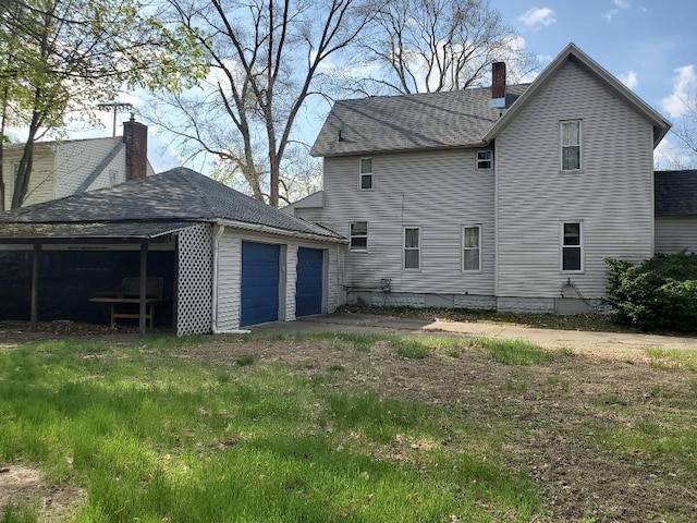 429 S Arnold, Mount Pleasant, MI 48858 - rear view of property with an outbuilding, an attached garage, a chimney, and driveway