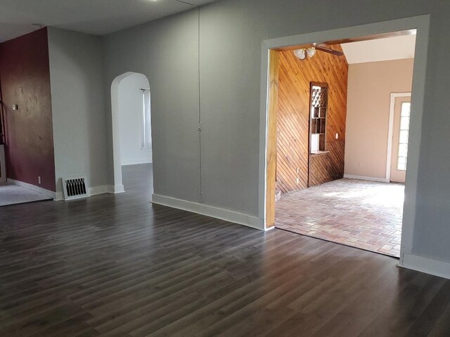 429 S Arnold, Mount Pleasant, MI 48858 - unfurnished living room with ceiling fan, arched walkways, dark wood finished floors, baseboards, and visible vents
