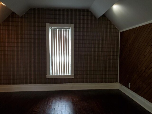 429 S Arnold, Mount Pleasant, MI 48858 - additional living space featuring wood-type flooring, baseboards, lofted ceiling, and wallpapered walls