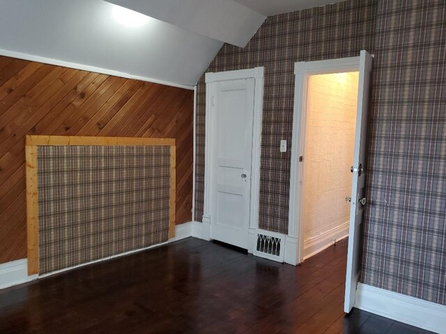429 S Arnold, Mount Pleasant, MI 48858 - additional living space featuring baseboards, vaulted ceiling, wallpapered walls, and wood finished floors