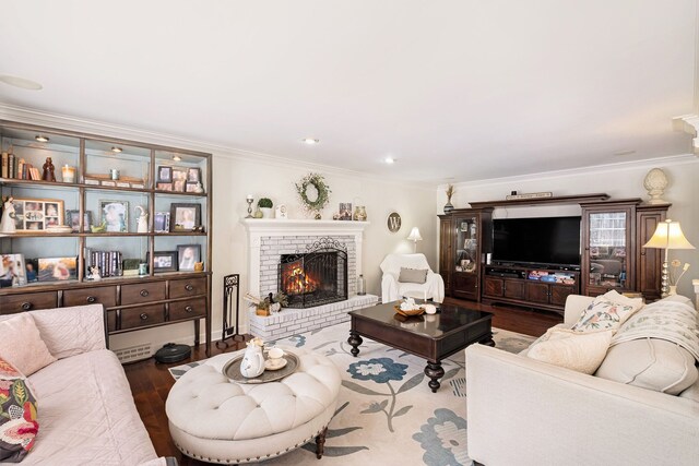 living room with crown molding, a brick fireplace, and wood finished floors