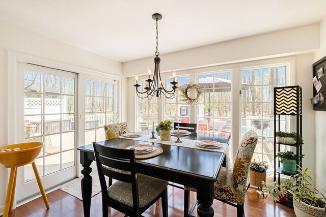 dining area with wood finished floors and a notable chandelier