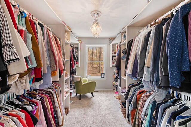 walk in closet with an inviting chandelier and carpet