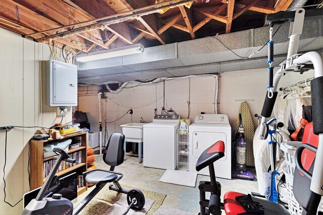 clothes washing area featuring washer and dryer, laundry area, a sink, and electric panel
