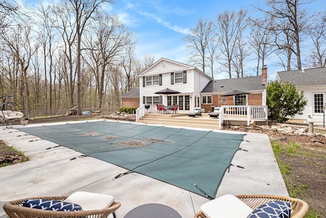 view of pool featuring fence, a covered pool, and a deck