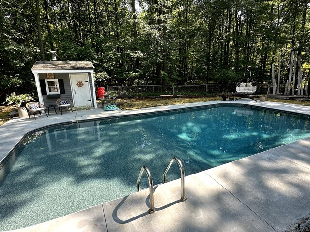 view of pool with a fenced in pool, fence, an outdoor structure, and a patio