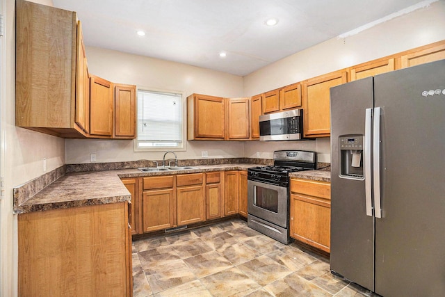 kitchen featuring dark countertops, recessed lighting, brown cabinets, a sink, and stainless steel appliances