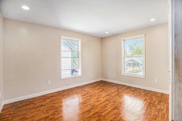 empty room featuring baseboards, recessed lighting, and wood finished floors