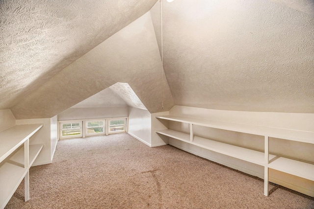 bonus room featuring carpet, a textured ceiling, and vaulted ceiling