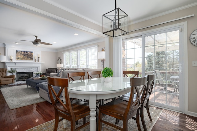1699 Devonwood Dr, Rochester Hills, MI 48306 - dining area with crown molding, a glass covered fireplace, dark wood finished floors, and ceiling fan with notable chandelier