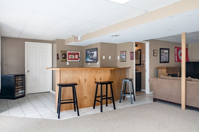 1699 Devonwood Dr, Rochester Hills, MI 48306 - kitchen featuring a breakfast bar area, beverage cooler, tile patterned floors, baseboards, and a drop ceiling