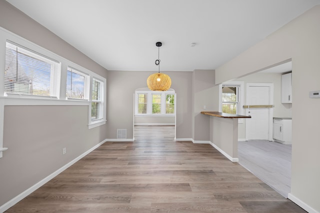 15866 Woodingham Dr, Detroit, MI 48238 - unfurnished dining area with visible vents, light wood finished floors, and baseboards