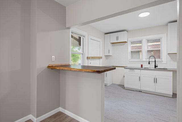15866 Woodingham Dr, Detroit, MI 48238 - kitchen with a sink, white cabinetry, a wealth of natural light, and tasteful backsplash