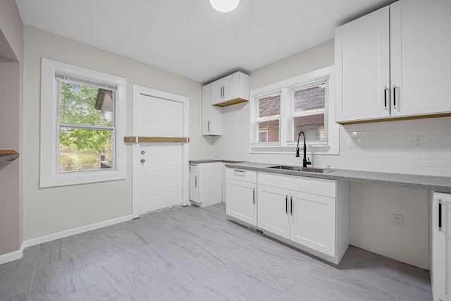 15866 Woodingham Dr, Detroit, MI 48238 - kitchen with backsplash, white cabinets, baseboards, and a sink
