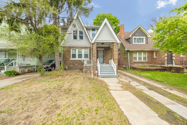 15866 Woodingham Dr, Detroit, MI 48238 - tudor-style house featuring covered porch and brick siding