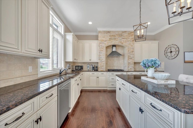 kitchen with a sink, dark wood finished floors, wall chimney exhaust hood, stainless steel appliances, and ornamental molding