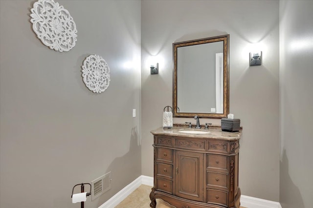bathroom featuring vanity, baseboards, and visible vents
