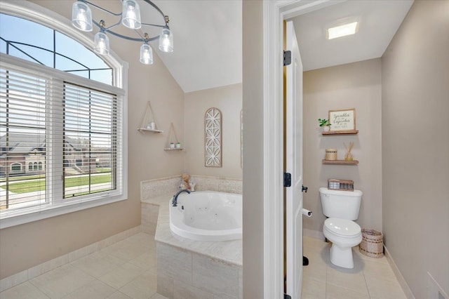 bathroom with tile patterned floors, baseboards, toilet, and a tub with jets