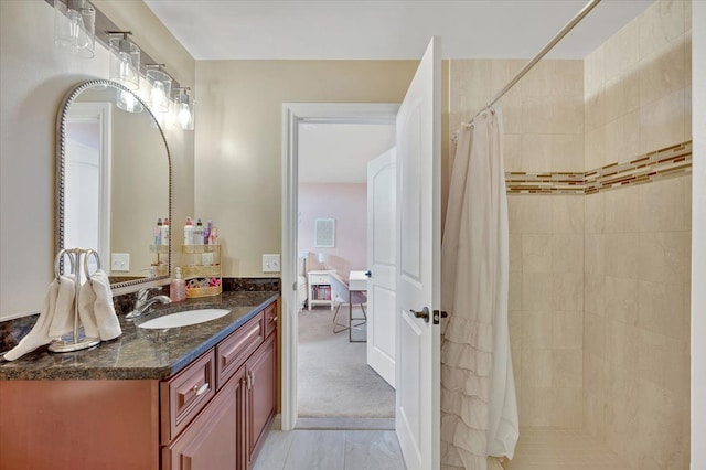 bathroom featuring a tile shower and vanity